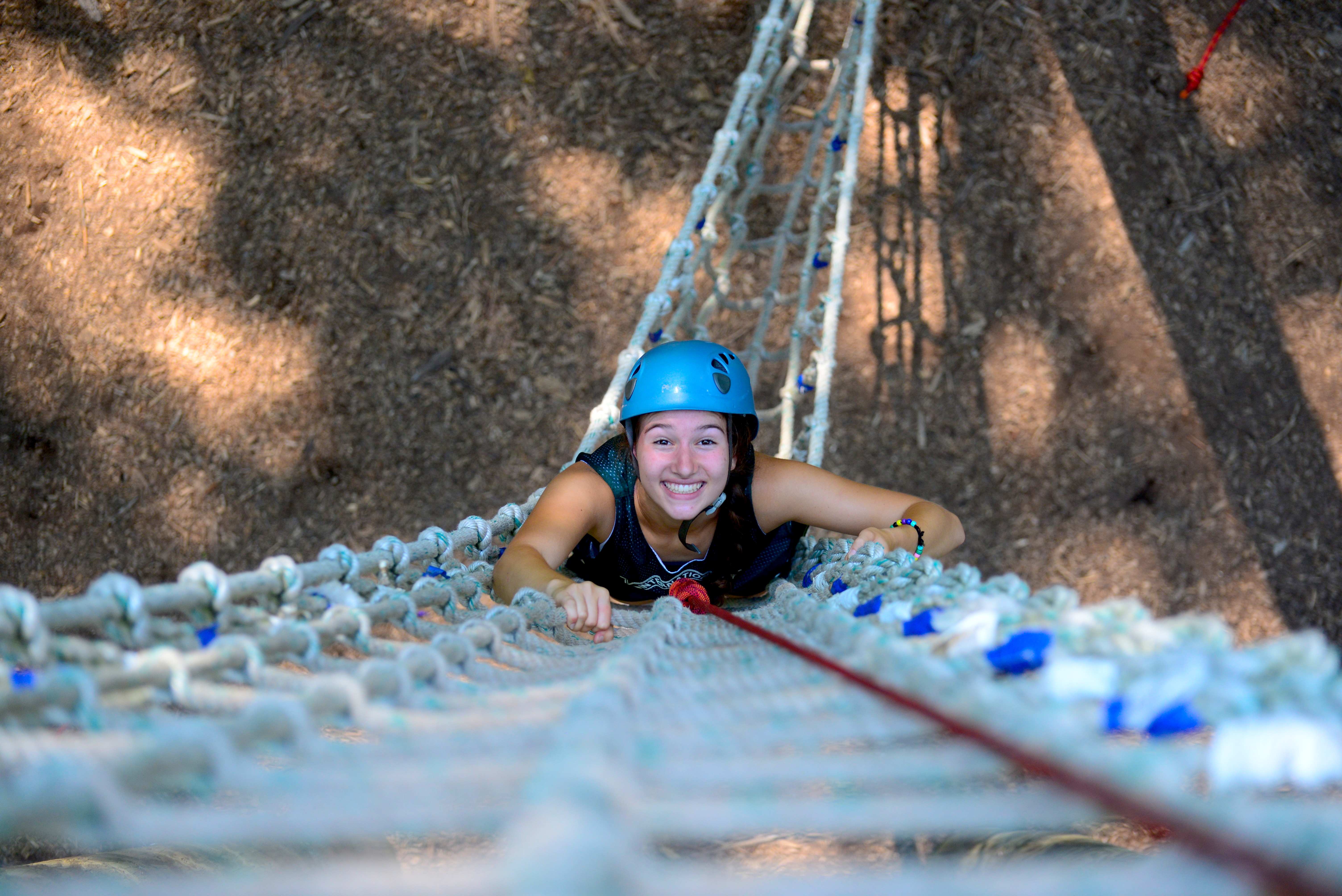 girl climbing up ropes course