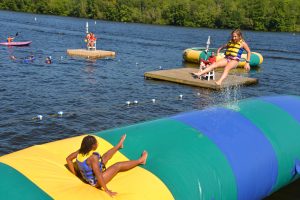 girls jumping on the blob at summer camp